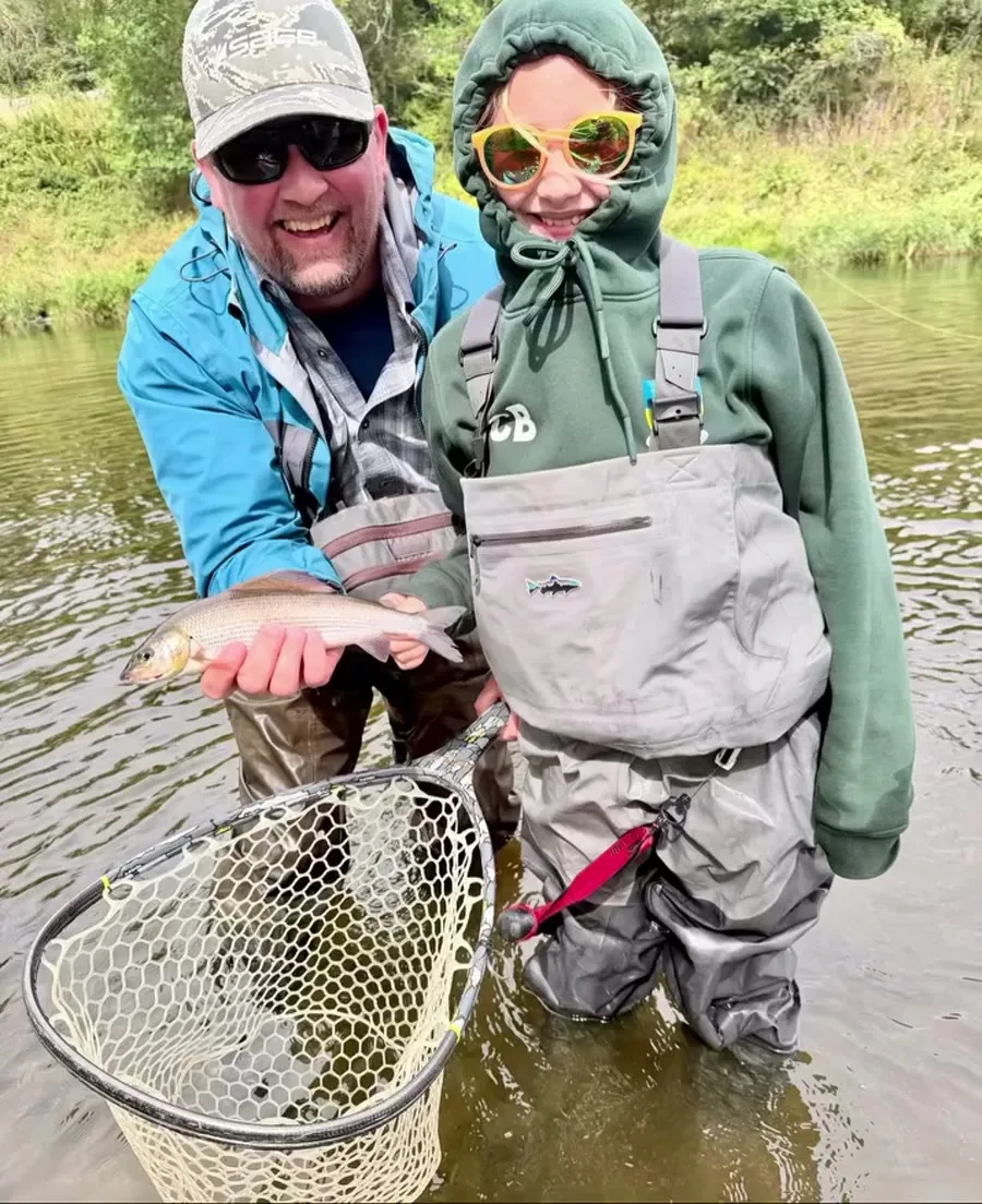 Guide and guest sharing a successful fishing moment in a Scottish river