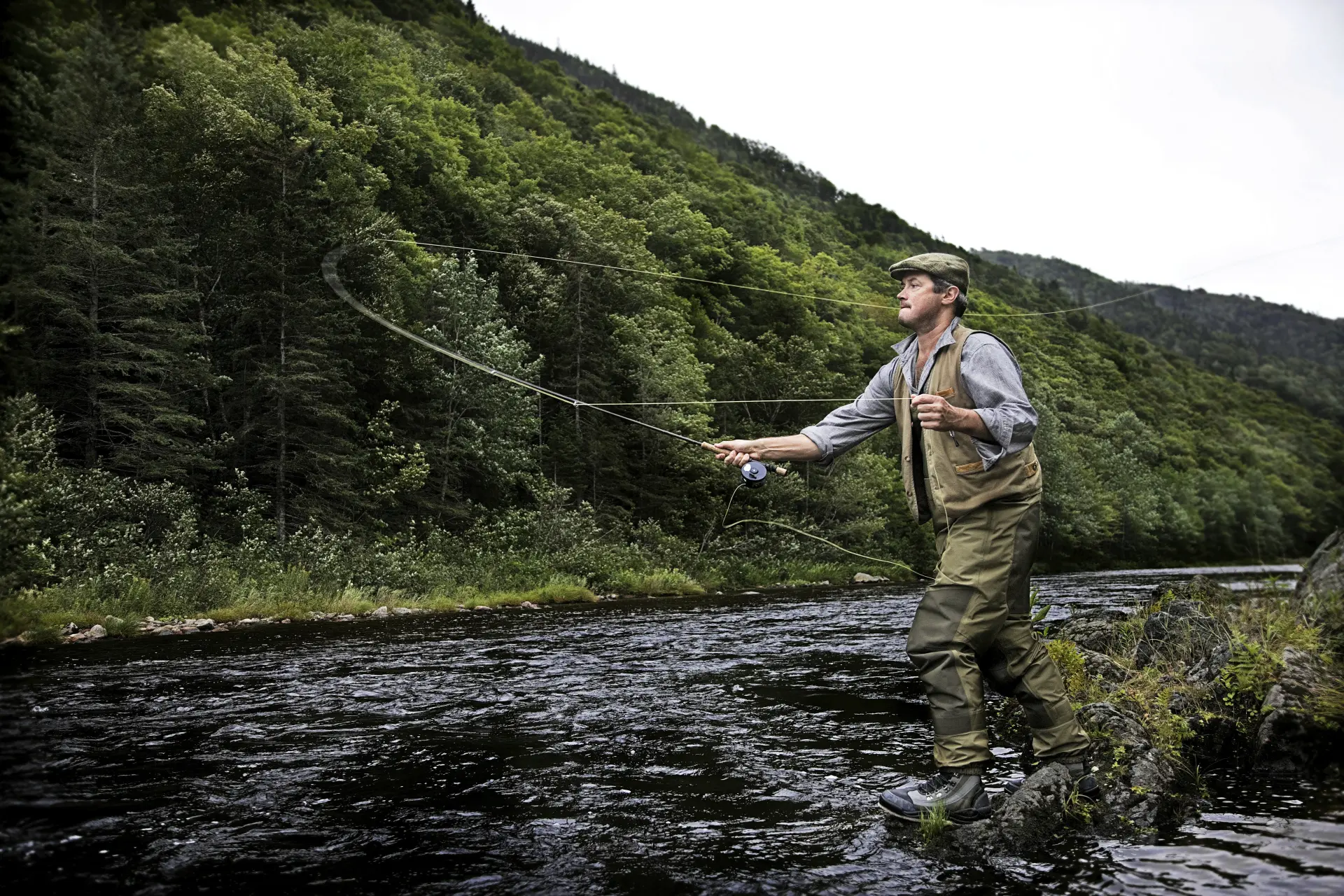 Fly angler casting on a scenic Scottish river
