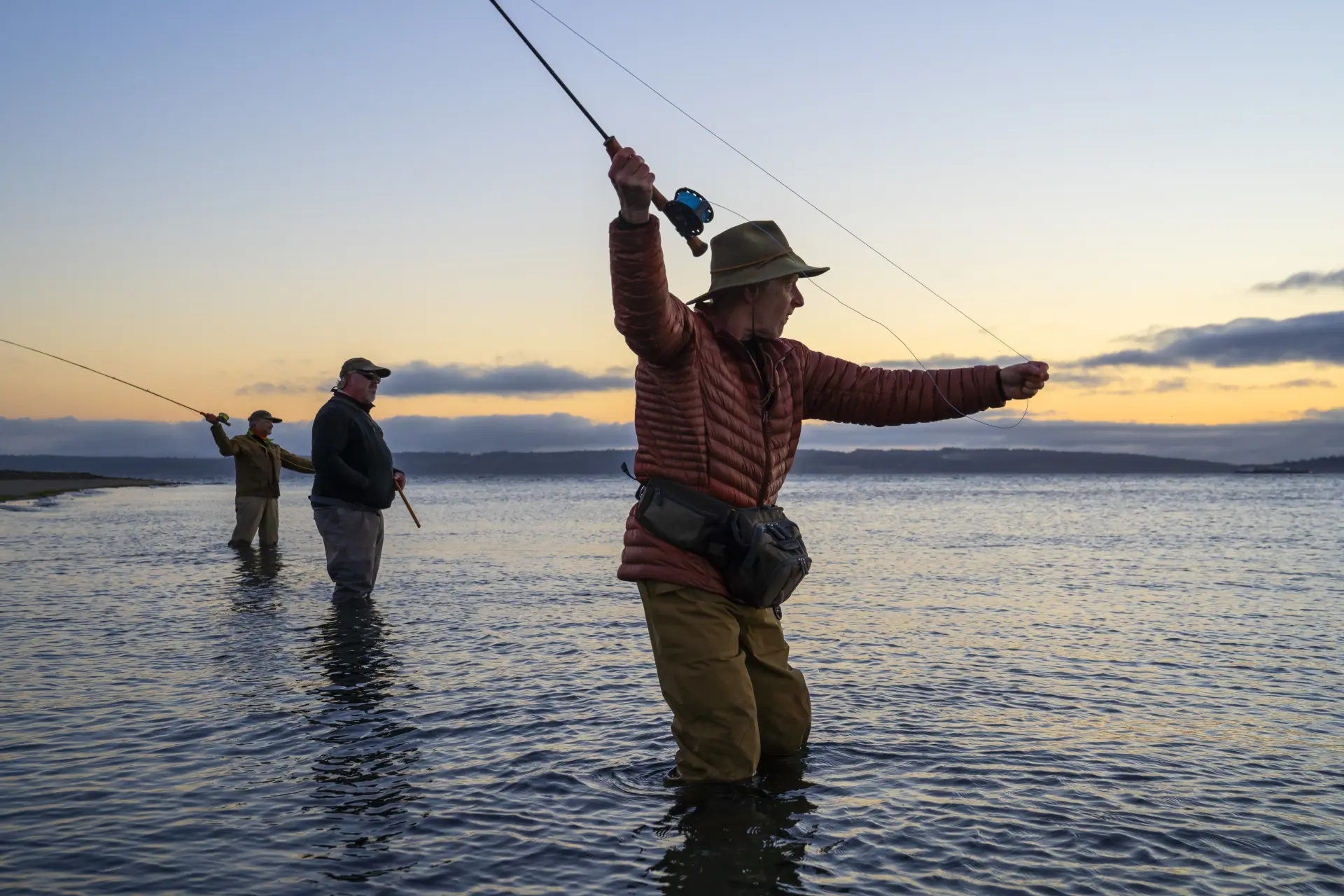 Guests fly fishing on Scottish water at sunset